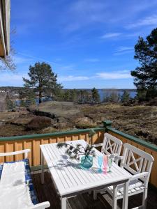 a white table and chairs on a deck with a view at Ikigaiisättra 44 in Åkersberga +16 photos