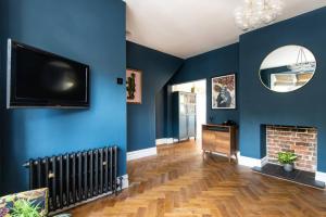 a living room with blue walls and a flat screen tv at Newly renovated Victorian house with free parking in Portslade