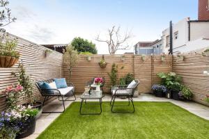 een kleine tuin met stoelen en een tafel op een gazon bij Newly renovated Victorian house with free parking in Portslade