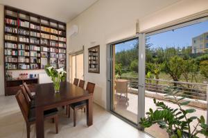a dining room with a table and a balcony at Gea Maleme in Maleme