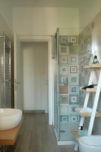 baño con lavabo y aseo y pared con cuadros en Casa Pierina, en Santa Marinella