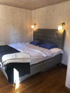 a bedroom with a large bed with two blue pillows at Ikigaiisättra 44 in Åkersberga