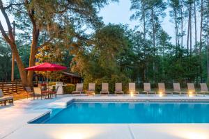 una piscina con sillas, mesa y sombrilla en Manders Manor, en Perry