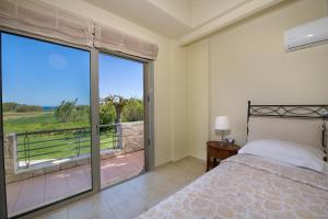 a bedroom with a bed and a large window at Gea Maleme in Maleme