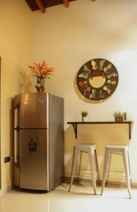 a kitchen with a refrigerator and a table and two stools at Lindo apartamento con terraza en Bello Ant in Bello