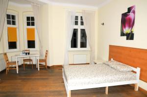1 dormitorio con cama, mesa y ventanas en Economic Mandala Apartment en Poznan