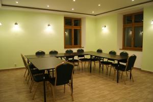 una sala de conferencias con una mesa larga y sillas en Stadnina Koni Kierzbuń, en Barczewo