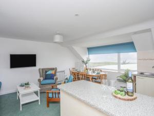 a kitchen and living room with a counter and a table at Ysgo - 6 Ty'n Don in Abersoch