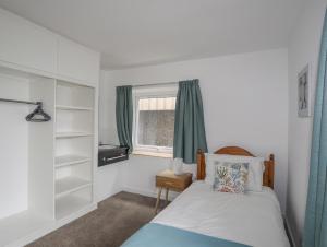 a bedroom with a bed and a window at Ysgo - 6 Ty'n Don in Abersoch