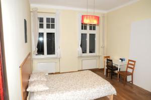 1 dormitorio con 1 cama, 1 mesa y 2 ventanas en Economic Mandala Apartment en Poznan