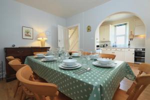 a dining room table with a green and white table cloth at Eddystone in Kingsbridge