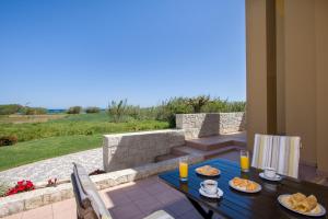 a table with plates of food on a patio at Gea Maleme in Maleme