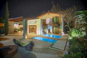una casa con piscina por la noche en Bottega Hotel Boutique, en Valle de Guadalupe