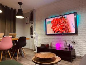 sala de estar con TV en una pared de ladrillo en KB HOME Puertollano, en Puertollano