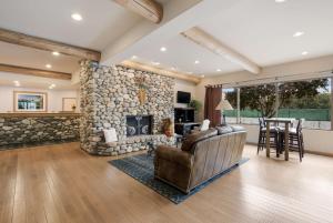a living room with a stone fireplace and a leather couch at Best Western Plus Kentwood Lodge in Sun Valley