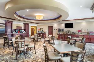 Best Western Plus Chalmette Hotel في تشالميته: مطعم بطاولات وكراسي وبار