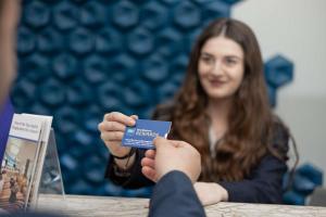 una mujer sentada en una mesa con una tarjeta de crédito en Best Western Tbilisi Art Hotel, en Tiflis