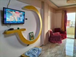 sala de estar con TV de pantalla plana en la pared en Flores casas de playa en Alexandría