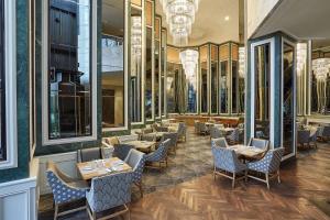 a restaurant with tables and chairs and mirrors at Southern Sun Cape Sun in Cape Town