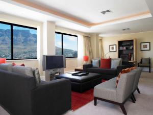a living room with couches and a flat screen tv at Southern Sun Cape Sun in Cape Town