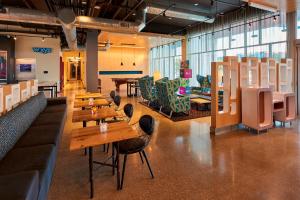 un restaurante con mesas de madera y sillas en una habitación en Aloft Cleveland Airport en North Olmsted