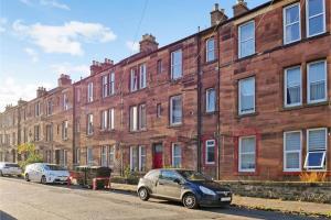 two cars parked in front of a brick building at 2 Bedrooms Flat Central Edinburgh, Sleeps 6, in the shadow of Holyrood Park and Arthur's Seat with free parking, two bed rooms in Edinburgh