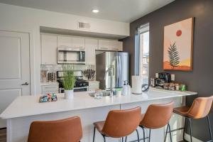 a kitchen with a large white counter with chairs at Charming Retreat in Heart of SLC in Salt Lake City
