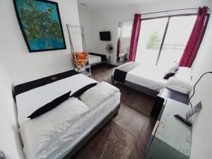 a small bedroom with two beds and a window at RCH Suite in Mexico City
