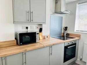 a kitchen counter with a microwave and a sink at House for Contractors and Families in Aldershot