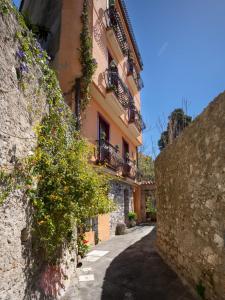 an alley in a building with flowers and plants at B&B RE TANCREDI in Taormina