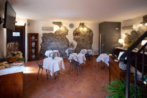 a restaurant with tables and chairs and a stone wall at B&B RE TANCREDI in Taormina
