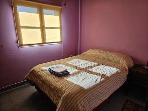 a small bedroom with a bed with a window at La Casa de Kuky in Esquel
