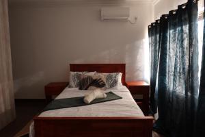 a bedroom with a bed with black curtains at Lolani Apartments in Lusaka