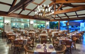 een eetkamer met tafels en stoelen en een kroonluchter bij Akka Claros Hotel - All Inclusive in Kemer