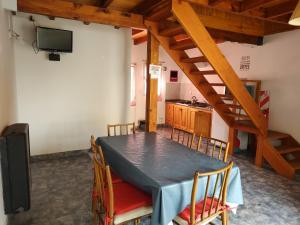 a dining room with a table with chairs and a television at COMPLEJO AIKEN CURA in Junín de los Andes