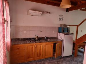 La cuisine est équipée d'un réfrigérateur blanc et d'un évier. dans l'établissement COMPLEJO AIKEN CURA, à Junín de los Andes