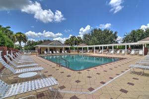 a swimming pool with lounge chairs and a resort at Home with Lanai and Community Perks in The Villages! in Leesburg