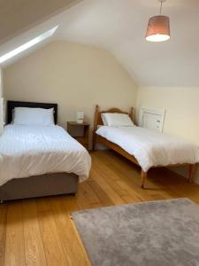 una camera con 2 letti, un tappeto e una lampada di Stewarts House a Newtownstewart