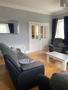 uma sala de estar com um sofá e uma mesa em Stewarts House em Newtownstewart