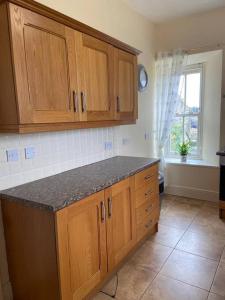 a kitchen with wooden cabinets and a counter top at Stewarts House in Newtownstewart +21 photos