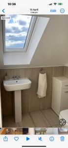 La salle de bains est pourvue d'un lavabo et d'une lucarne. dans l'établissement West Highland Way Rooms ED30002F, à Milngavie