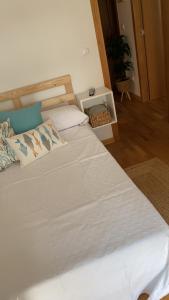 a bedroom with a large bed with white sheets at A Coviña in Vilagarcia de Arousa