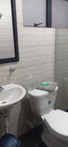 y baño con aseo blanco y lavamanos. en Apartamento muy amplio, Familiar cerca al Aeropuerto el Dorado, en Bogotá