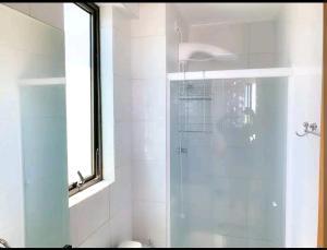 baño con ducha y puerta de cristal en Belo Flat à beira mar en Recife