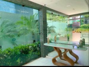 baño con una mesa y una gran ventana de cristal en Belo Flat à beira mar en Recife