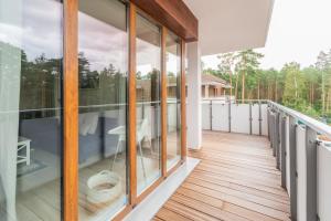 a balcony with glass doors and wooden floors at Apartament Stegna Marine in Stegna