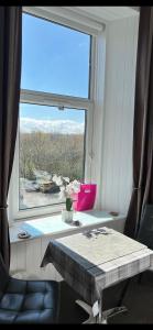 a room with a large window with a table and a chair at West Highland Way Rooms ED30002F in Milngavie