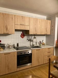 a kitchen with wooden cabinets and a stove top oven at Chalet Madonna di Campiglio CIPAT ZERO22143-AT-ZERO69206 in Madonna di Campiglio