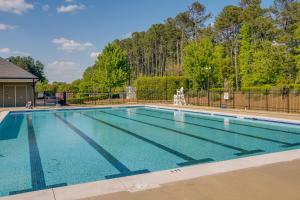 une grande piscine avec une clôture et des arbres dans l'établissement Sunny Apex Vacation Rental with Pool Access!, à Apex