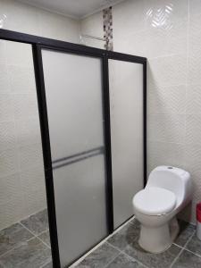 Hosteria Puerta del Nus في Cisneros: حمام مع مرحاض ومقصورة دش